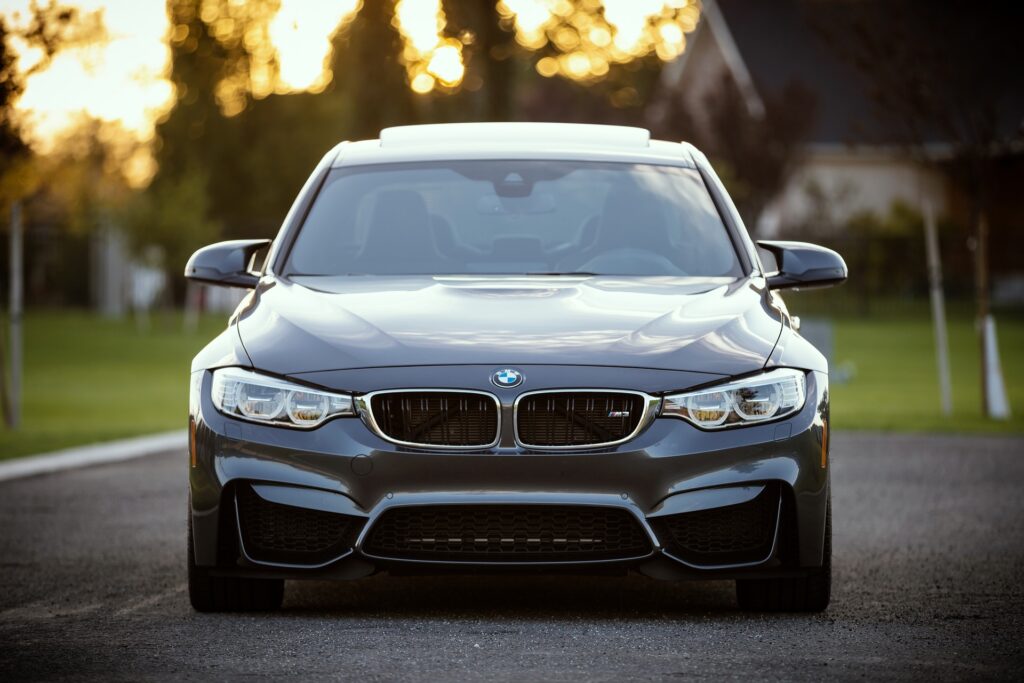 Dunkelgrauer BMW in Frontansicht bei Abendlicht