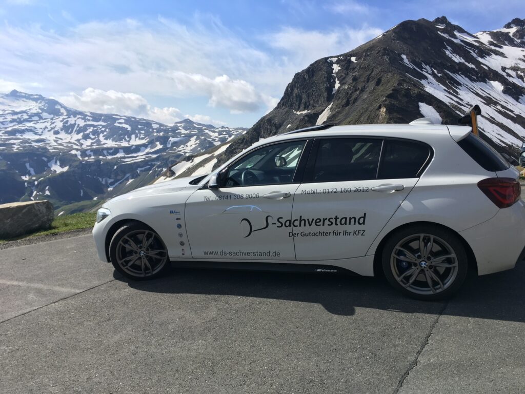 Seitenansicht: weißer BMW 1er des Kfz-Gutachters Dirk Steffen mit DS-Sachverstand-Beschriftung an einer Passstraße in den Bergen