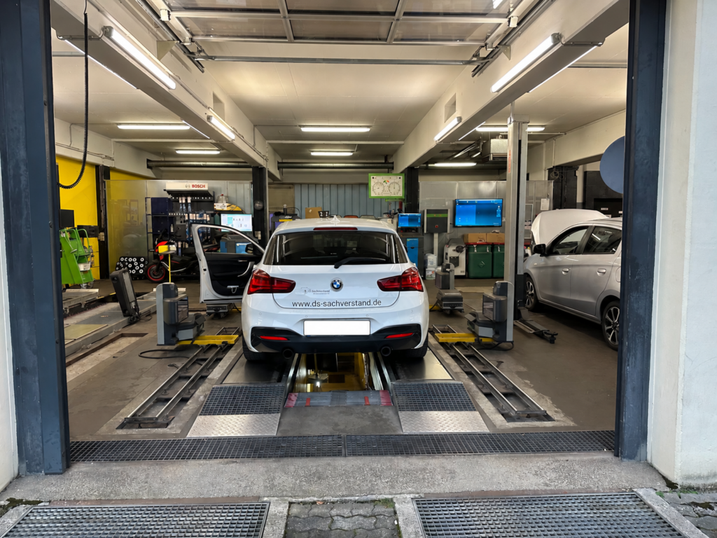 Weißer BMW 1er des Kfz-Gutachters Dirk Steffen mit DS-Sachverstand-Beschriftung in einer Kfz-Werkstatt auf der Hebebühne