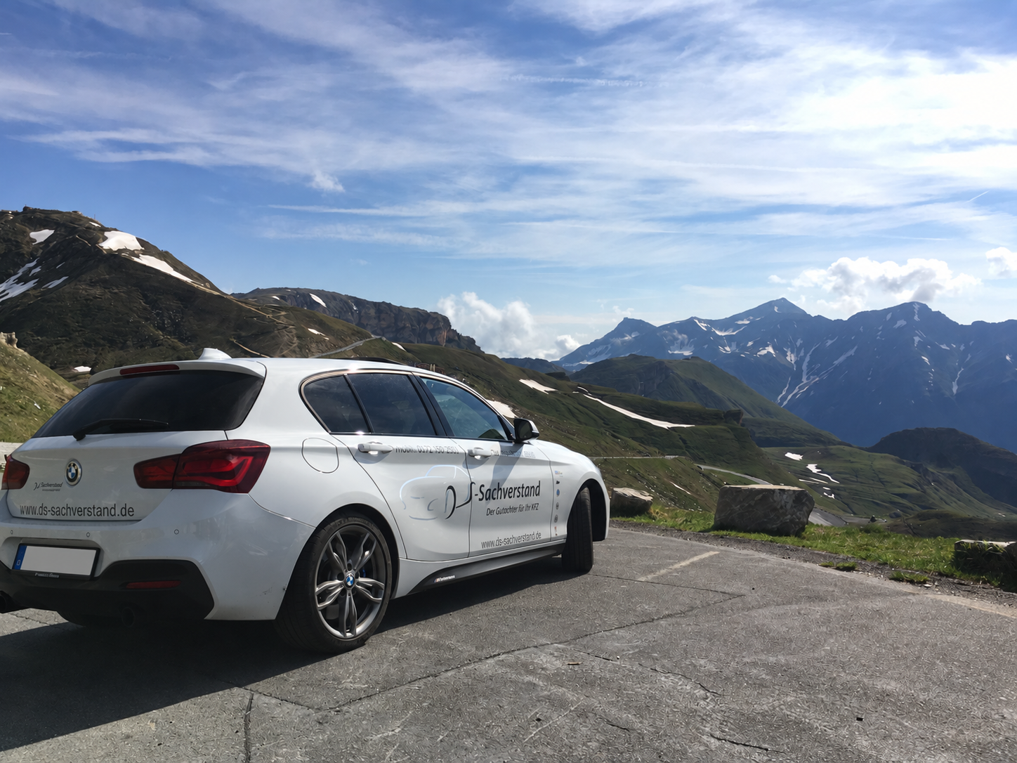 Weißer BMW 1er des Kfz-Gutachters Dirk Steffen mit DS-Sachverstand-Beschriftung vor schneebedecktem Alpenpanorama